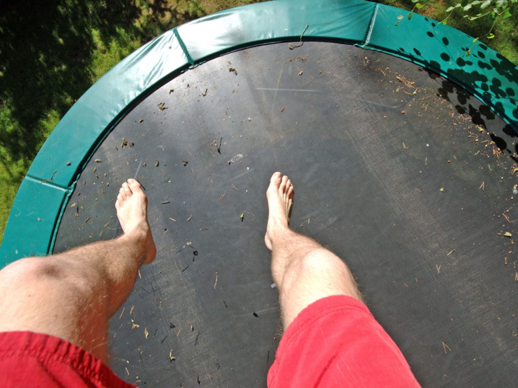 A Man's Legs and A Green Trampoline.