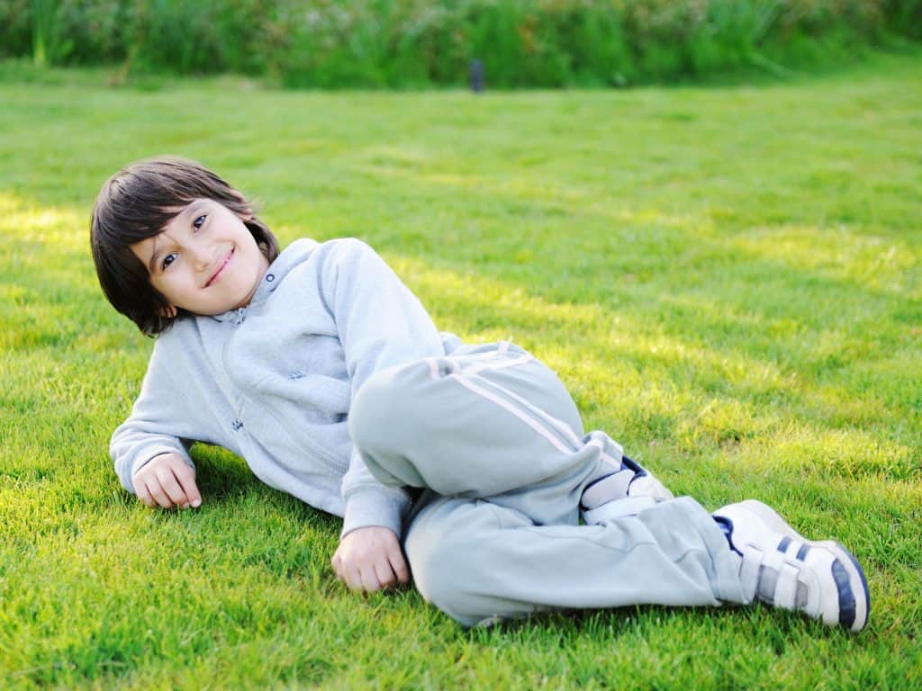 Boy Laying In The Grass During Simon Says Game.